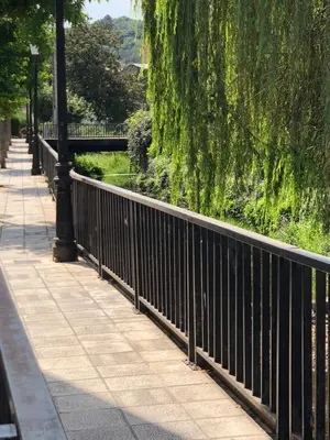 a black fence next to a sidewalk next to a bridge at Andaina in Sarria