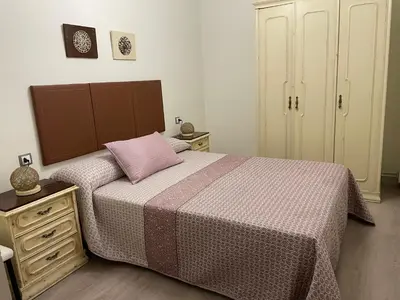 a bedroom with a bed with a pink pillow on it at CALLE HUERTAS Nº 17 - 1º in Lugo