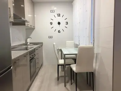 a kitchen with a table and a clock on the wall at CALLE HUERTAS Nº 17 - 1º in Lugo