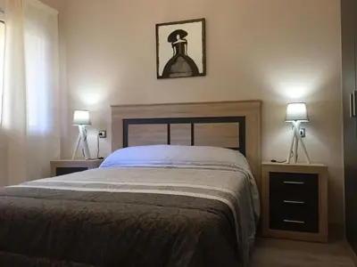 a bedroom with a large bed with two lamps on it at CALLE HUERTAS Nº 17 - 1º in Lugo