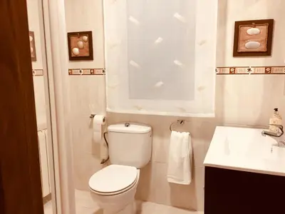 a white bathroom with a toilet and a sink at CALLE HUERTAS Nº 17 - 1º in Lugo
