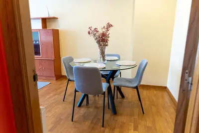 a dining room table with chairs and a vase of flowers at Puente Romana in San Ciprián