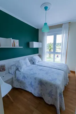 a bedroom with a bed and a green wall at Puente Romana in San Ciprián