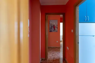 a hallway with orange walls and a doorway at Puente Romana in San Ciprián