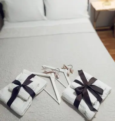 a pair of towels on a bed with black and white bows at A&L Playa in Viveiro