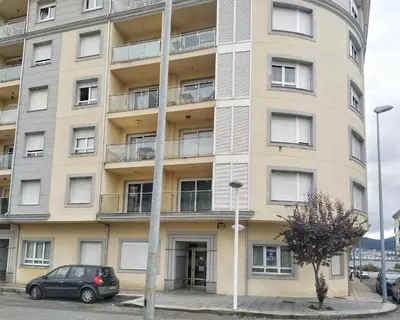 an apartment building with a car parked in front of it at A&L Playa in Viveiro