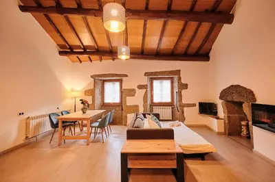 a table with two glasses and a bottle on it at Casa Grande de Covas-Apartamentos Boutique Turísticos- Ribeira Sacra in Taboada