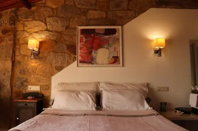 a bedroom with a bed in a stone wall at Casa do Cebro Casa con piscina y jacuzzi privados in Santiago de Compostela