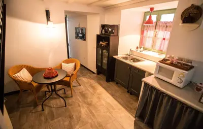 a small kitchen with a table and chairs and a microwave at Casa de Abaixo in Rinlo
