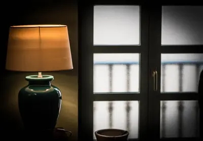 a lamp sitting on a table next to a window at Casa de Abaixo in Rinlo