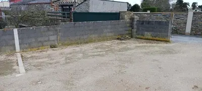 a fence in a yard next to a building at Casa de Abaixo in Rinlo