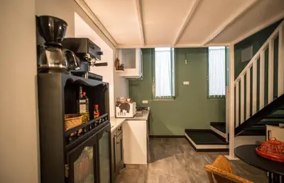 a small kitchen with a stove and a staircase at Casa de Abaixo in Rinlo