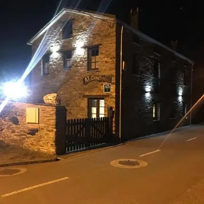 a stone building with lights on the side of it at Apartamentos Carola in San Tirso de Abres