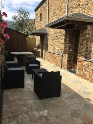 a patio with chairs and a table in a building at Apartamentos Carola in San Tirso de Abres