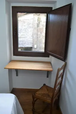 a wooden desk in a room with a window at Fogar do Pumar in Pantón