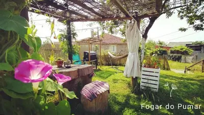 a garden with a wooden table and a pergola at Fogar do Pumar in Pantón