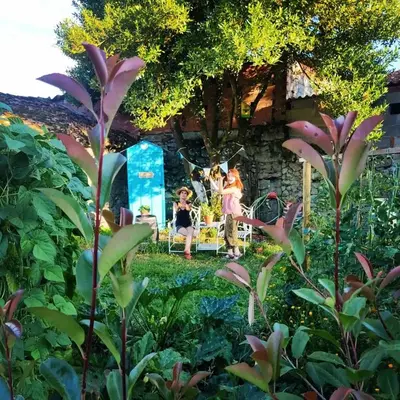 a group of people sitting on a bench in a garden at Fogar do Pumar in Pantón