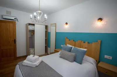 a bedroom with a large white bed with blue walls at Fogar do Pumar in Pantón
