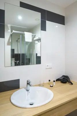 a bathroom with a white sink and a mirror at Hotel Concheiros in Santiago de Compostela