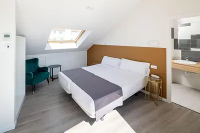 a bedroom with a large bed and a bathroom at Hotel Concheiros in Santiago de Compostela
