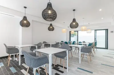 a dining room with tables and chairs and pendant lights at Hotel Concheiros in Santiago de Compostela