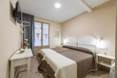 a bedroom with a large bed and a window at Pensión Luis in Arzúa