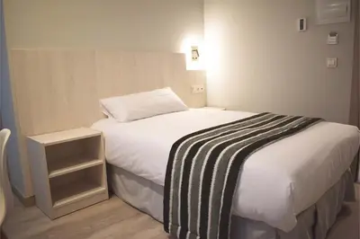 a bedroom with a bed with a black and white blanket at Santa Filomena in Santiago de Compostela
