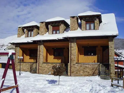 a house with snow on top of it in the snow at Apartamentos Rurales L´Abiseu in Caboalles de Abajo