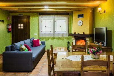 a living room with a blue couch and a table at Apartamentos Rurales L´Abiseu in Caboalles de Abajo