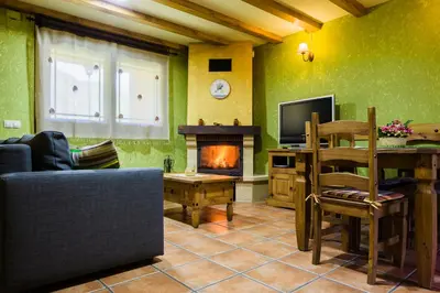a living room with a couch and a fireplace at Apartamentos Rurales L´Abiseu in Caboalles de Abajo