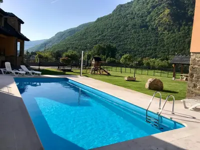 a swimming pool with a view of a mountain at Apartamentos Rurales L´Abiseu in Caboalles de Abajo