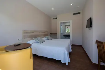 a bedroom with two beds and a table and a tv at Alojamientos rurales O Acivro in A Rúa