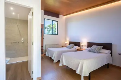 a hotel room with two beds and a bathroom at Alojamientos rurales O Acivro in A Rúa