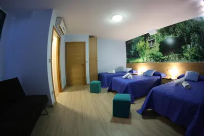 a room with two beds and a painting on the wall at Pension Pardellas in Palas de Rei