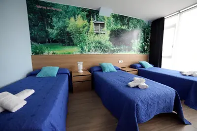 a room with two beds with blue sheets and a window at Pension Pardellas in Palas de Rei