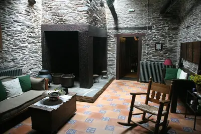 a living room with a couch and a stone wall at Casa Grande da Ferreria de Rugando in Rugando