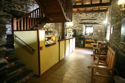 a kitchen with a refrigerator and a staircase in a room at Casa Grande da Ferreria de Rugando in Rugando