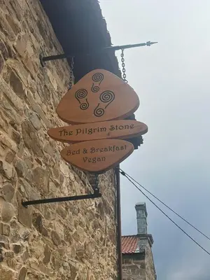 a sign for the pizza store on a building at The Pilgrim Stone - Vegan B&B in Rabanal del Camino