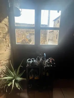 a shelf with shoes in front of a window at The Pilgrim Stone - Vegan B&B in Rabanal del Camino