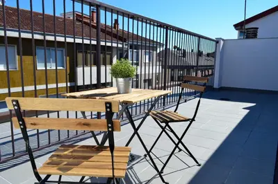 a wooden table and two chairs on a balcony at Hotel Alda Estación Ourense in Ourense