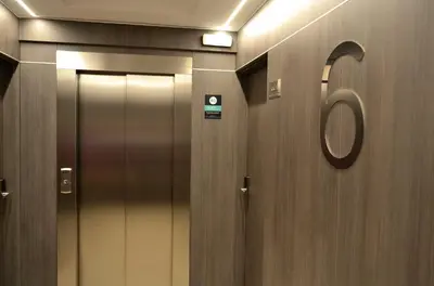 a bathroom with two elevators and a door with a mirror at Hotel Alda Estación Ourense in Ourense
