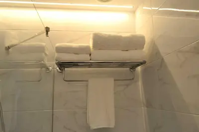 a bathroom with white towels on a towel rack at Hotel Alda Estación Ourense in Ourense