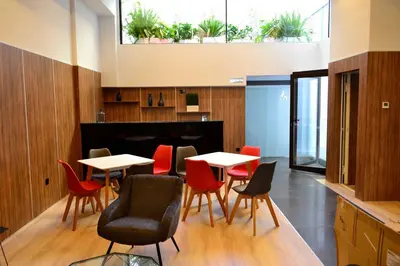 a dining room with tables and chairs and plants at Hotel Alda Estación Ourense in Ourense