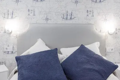 a bed with two blue pillows in a bedroom at La Pause in Arzúa