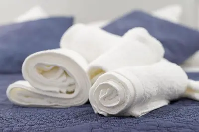 a pile of white towels on a bed at La Pause in Arzúa