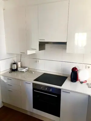 a kitchen with white cabinets and a black stove top oven at Lugo 360 in Lugo