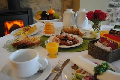 a table topped with plates of food and orange juice at Casa Ramiras in O Viso