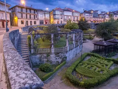 an old stone wall with a garden in a city at Casa Ramiras in O Viso