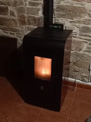 a black stove with a fire inside of it at Casa Rural del Acebo in Espinoso de Compludo