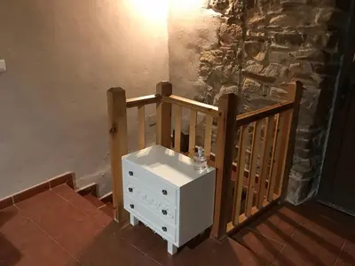 a small white dresser next to a wooden railing at Casa Rural del Acebo in Espinoso de Compludo